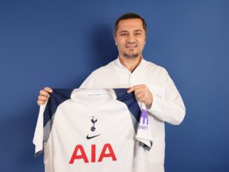 Bild zeigt, wie Dr. Abdulaziz Balwi ein Trikot des Premiere League Klubs Tottenham Hotspur in beiden Hände hält