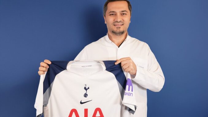 Bild zeigt, wie Dr. Abdulaziz Balwi ein Trikot des Premiere League Klubs Tottenham Hotspur in beiden Hände hält